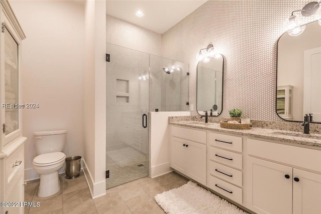 bathroom with vanity, a shower with door, and toilet