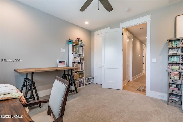 carpeted office space featuring ceiling fan