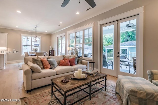 living room featuring crown molding, ceiling fan, and light hardwood / wood-style flooring