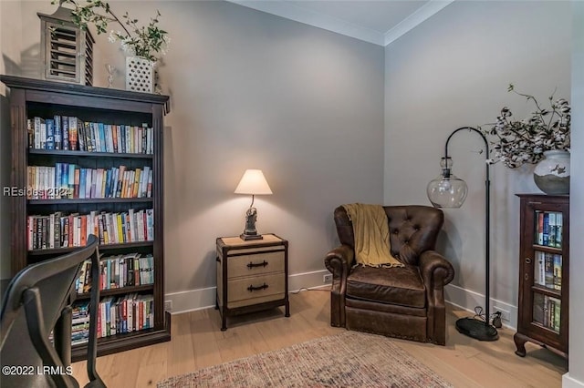 sitting room featuring ornamental molding and wood-type flooring