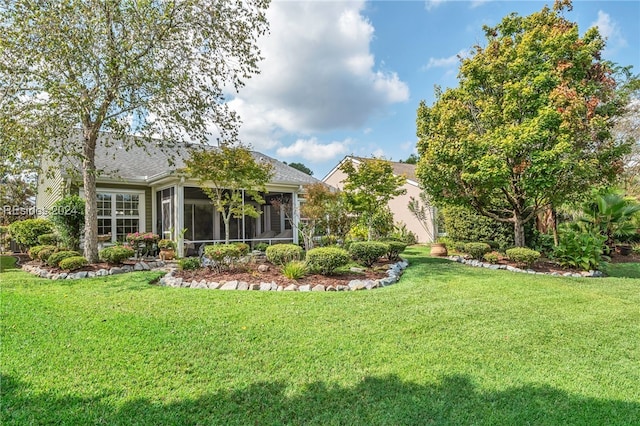 rear view of house featuring a sunroom and a yard