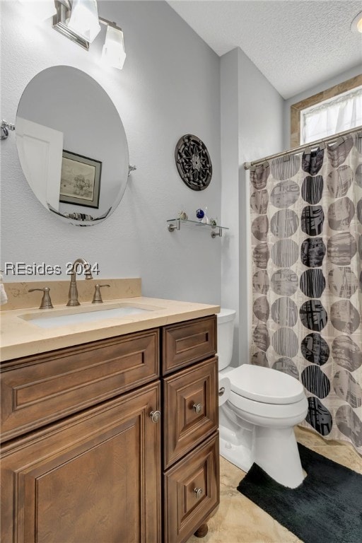 bathroom with vanity, curtained shower, toilet, and a textured ceiling