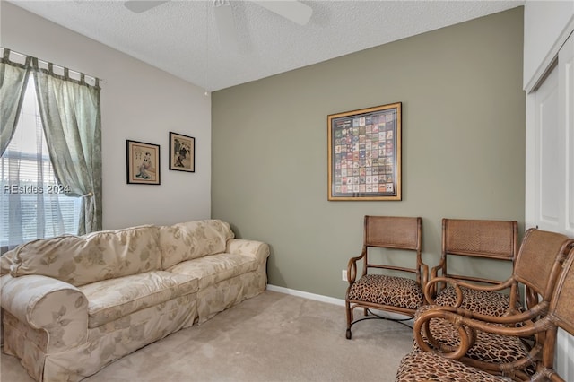 carpeted living room with ceiling fan and a textured ceiling