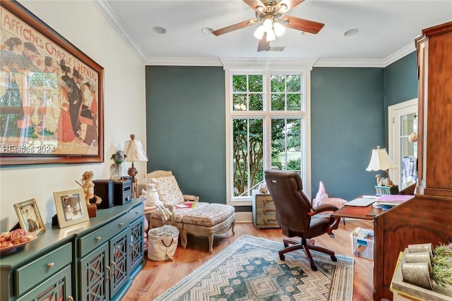 home office with ornamental molding, ceiling fan, and light wood-type flooring