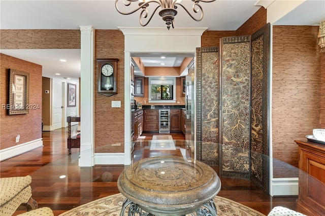 interior space with wine cooler, vanity, an inviting chandelier, and hardwood / wood-style flooring