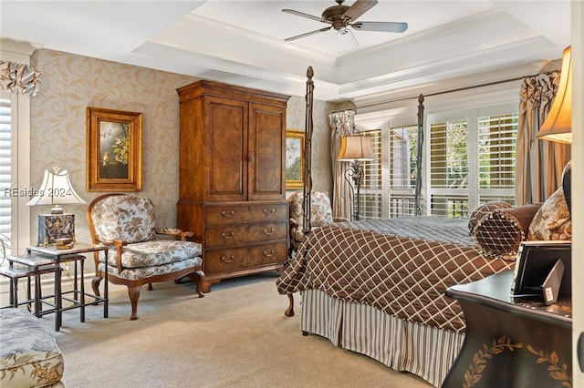 bedroom featuring ceiling fan, a raised ceiling, and light carpet