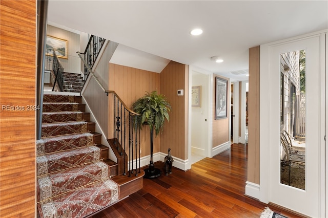 interior space with wood-type flooring and wooden walls