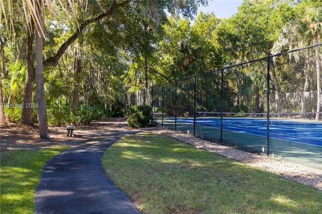 view of tennis court featuring a yard