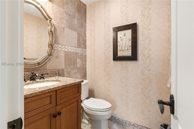 bathroom featuring vanity, backsplash, and toilet