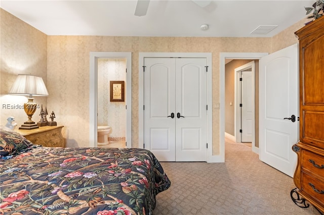 bedroom with light carpet, connected bathroom, a closet, and ceiling fan