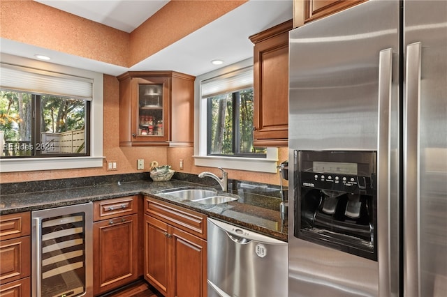 kitchen featuring wine cooler, sink, dark stone countertops, and appliances with stainless steel finishes