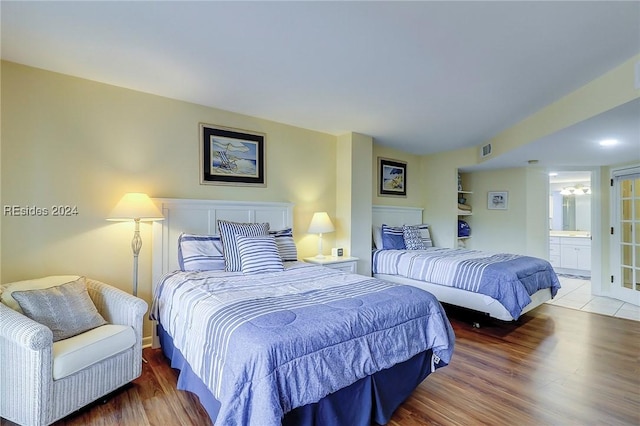 bedroom featuring wood-type flooring and connected bathroom