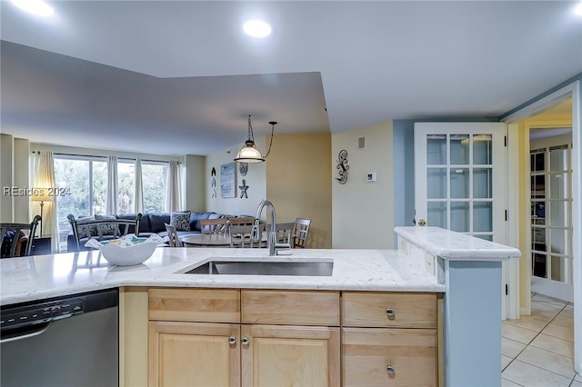 kitchen featuring light tile patterned flooring, light brown cabinetry, black dishwasher, sink, and hanging light fixtures