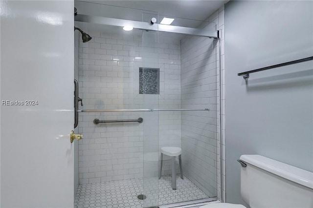 bathroom with toilet and a shower with shower door