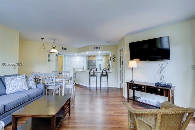 living room featuring hardwood / wood-style flooring and sink