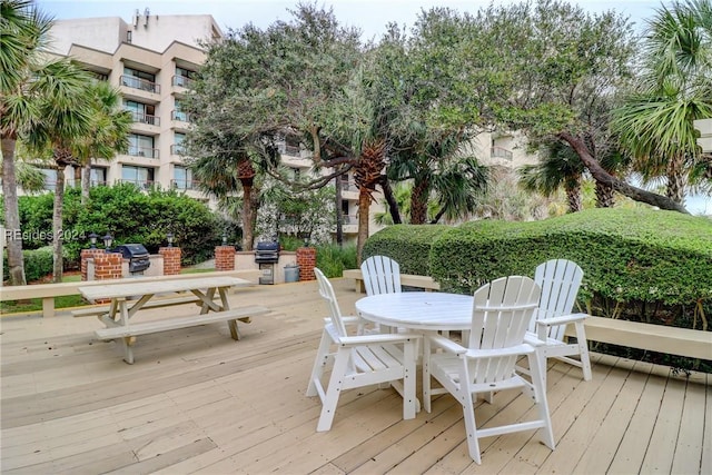 wooden terrace featuring grilling area and an outdoor kitchen