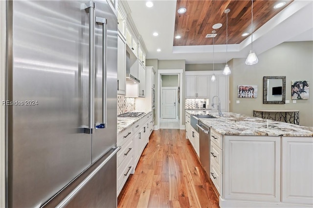 kitchen with pendant lighting, white cabinetry, backsplash, stainless steel appliances, and light stone countertops