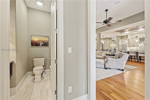 bathroom featuring toilet, tasteful backsplash, vanity, ceiling fan, and hardwood / wood-style floors