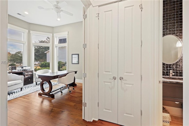 office area with ceiling fan, wood-type flooring, and sink