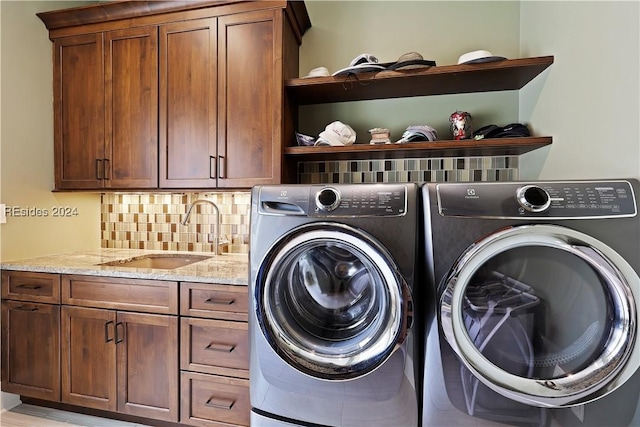 laundry room featuring separate washer and dryer, sink, and cabinets