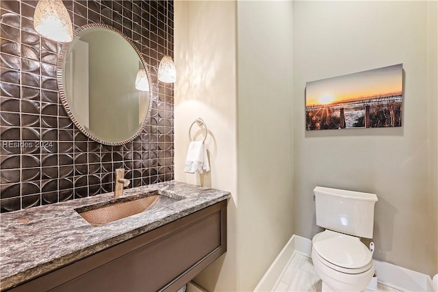 bathroom featuring vanity, backsplash, and toilet