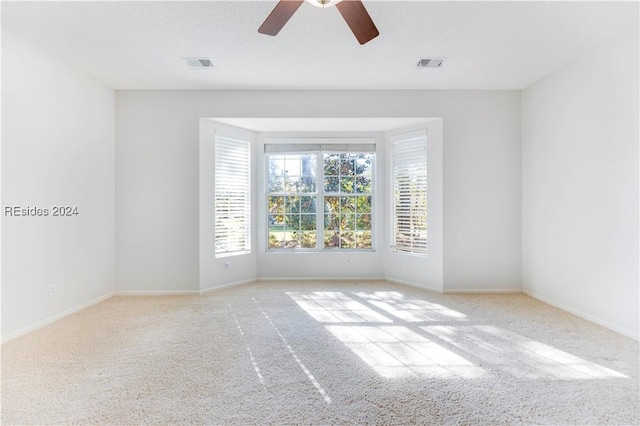 unfurnished room featuring ceiling fan and light colored carpet