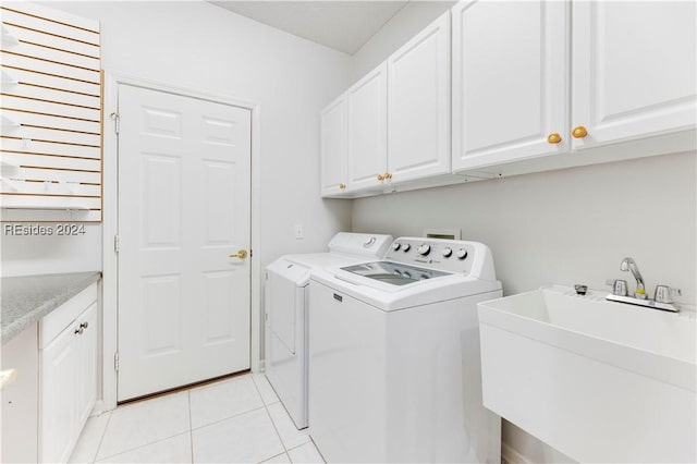 laundry room featuring cabinets, separate washer and dryer, sink, and light tile patterned floors