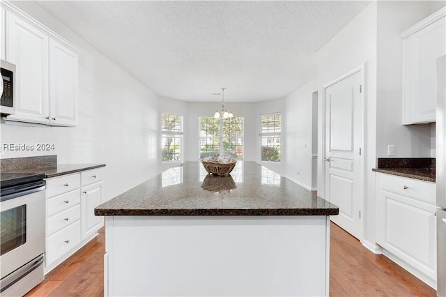 kitchen featuring white cabinetry, stainless steel electric stove, a kitchen island, and light wood-type flooring