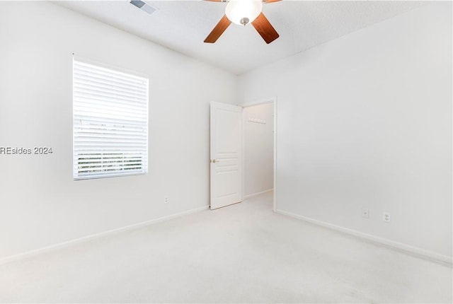 spare room with light colored carpet and ceiling fan