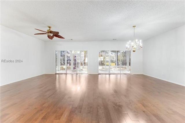 spare room featuring hardwood / wood-style flooring, ceiling fan with notable chandelier, and a textured ceiling