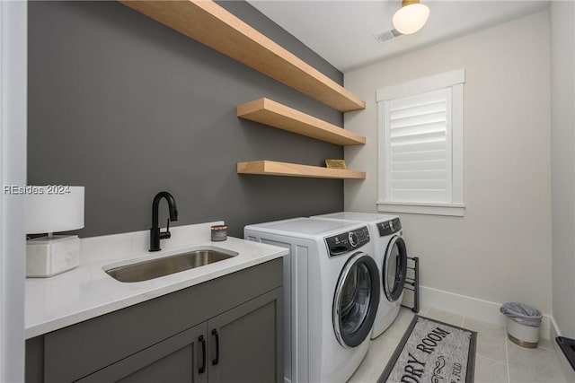 laundry area with light tile patterned flooring, cabinets, sink, and washing machine and dryer