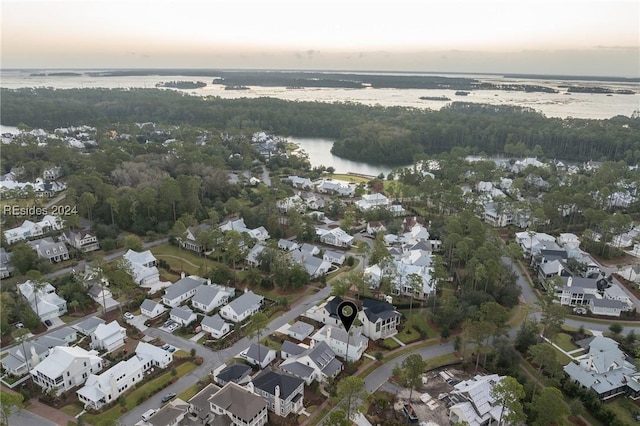 aerial view at dusk featuring a water view