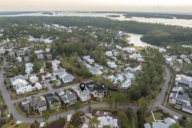 aerial view at dusk featuring a water view