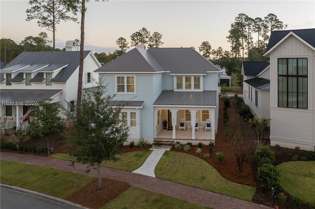 view of front of home with a porch and a lawn