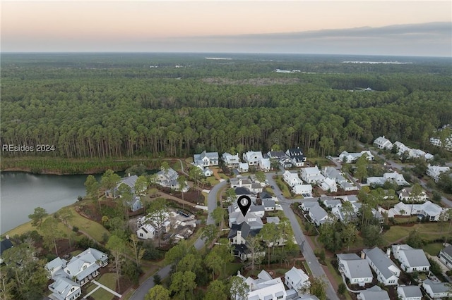 aerial view at dusk featuring a water view