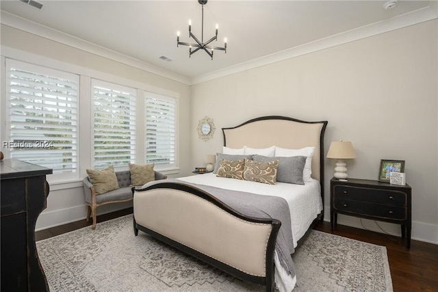 bedroom with dark hardwood / wood-style flooring, crown molding, and an inviting chandelier