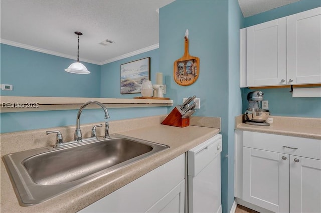 kitchen with white dishwasher, sink, pendant lighting, and white cabinets