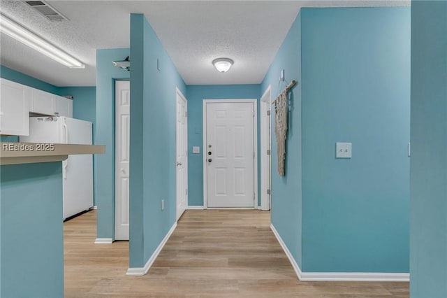 interior space with light hardwood / wood-style floors and a textured ceiling