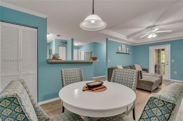 dining area with crown molding, ceiling fan, and light hardwood / wood-style floors