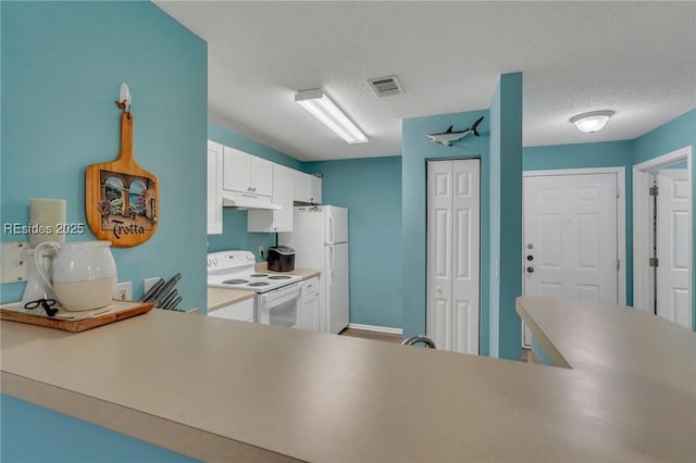 kitchen with white appliances, kitchen peninsula, a textured ceiling, and white cabinets