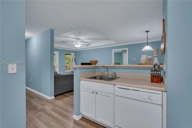 kitchen featuring pendant lighting, sink, crown molding, white dishwasher, and white cabinets