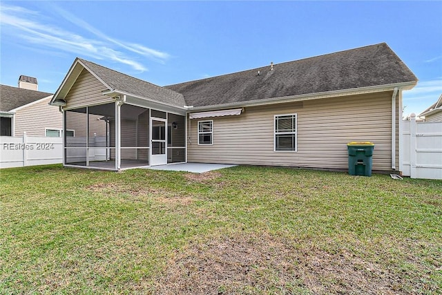 back of property with a lawn, a sunroom, and a patio