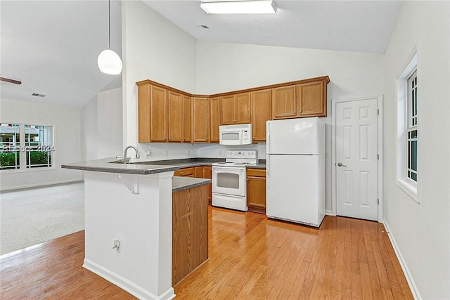 kitchen featuring high vaulted ceiling, decorative light fixtures, white appliances, kitchen peninsula, and light wood-type flooring