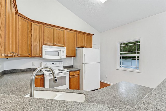 kitchen with vaulted ceiling, sink, and white appliances