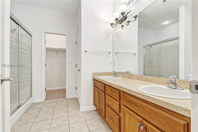 bathroom featuring tile patterned flooring, vanity, and a shower with door