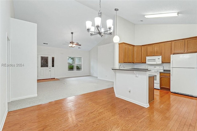 kitchen with a breakfast bar, sink, high vaulted ceiling, hanging light fixtures, and white appliances