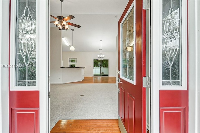 entrance foyer with carpet flooring and ceiling fan with notable chandelier