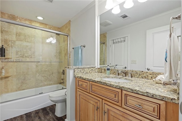 full bathroom featuring hardwood / wood-style flooring, bath / shower combo with glass door, ornamental molding, and toilet