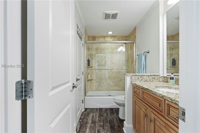 full bathroom featuring vanity, wood-type flooring, enclosed tub / shower combo, and toilet