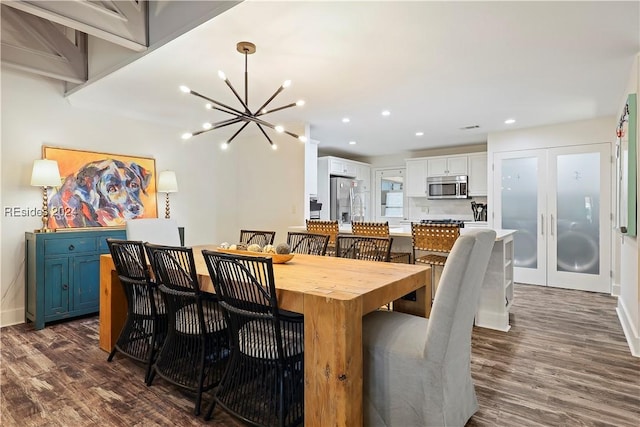 dining room featuring dark hardwood / wood-style flooring, a notable chandelier, and french doors